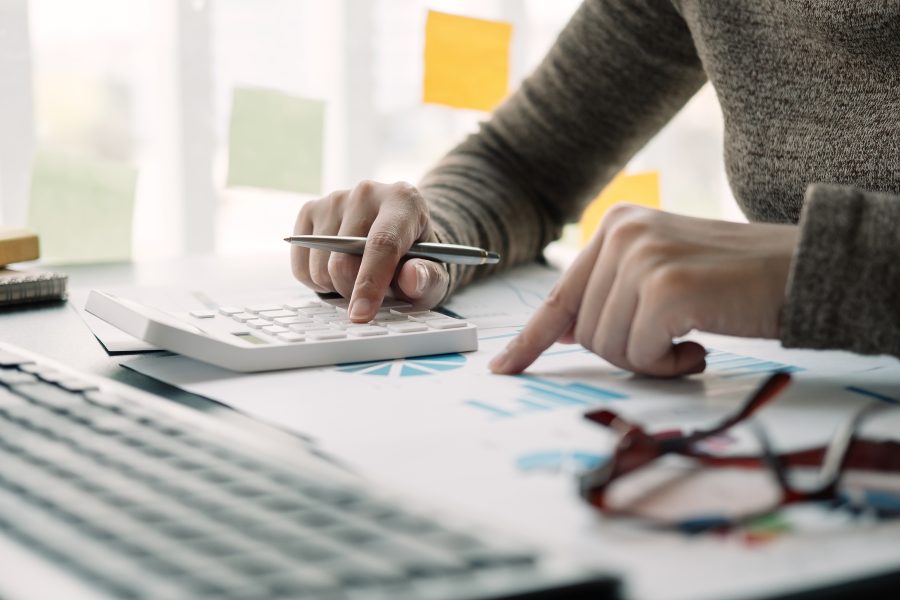 Close up view of bookkeeper or financial inspector hands making report, calculating or checking